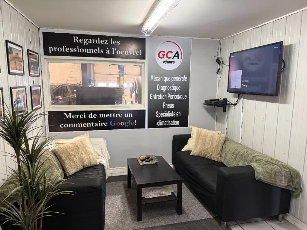 Salle d'attente GCA : canapés, vue sur l'atelier et panneaux de services
